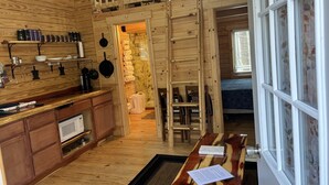A wooden cabin interior with a kitchen, dining area, and a loft bedroom. -     Secluded Log Cabin • Trails • 7 Minutes to French Lick • Pet Friendly (French Lick)