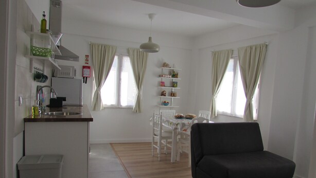 A compact living space with a kitchenette, dining area, and seating. - Mansão do Mé-mé - Apartamento Zêzere (Manteigas)