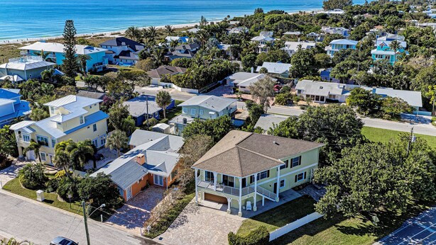 A coastal residential area with houses, some with balconies, and a view of the ocean.