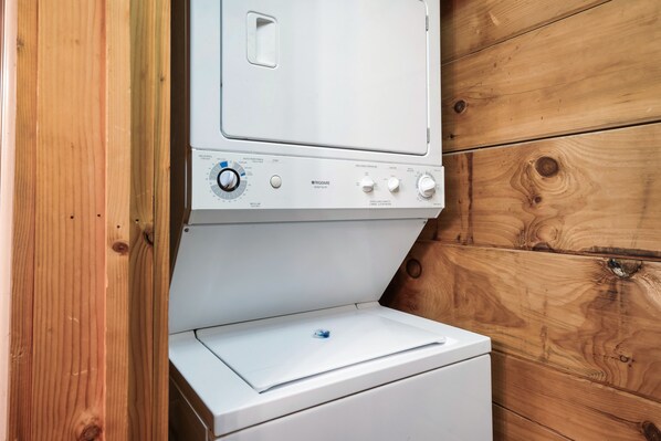 A white Frigidaire heavy-duty washer and dryer unit with control knobs and a small blue water level indicator.