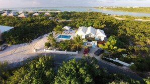 Resort com diversas acomodações tipo bangalô, piscina e vegetação tropical exuberante.