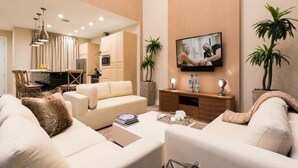 Un soggiorno moderno con un divano, un tavolino e una TV fissata al muro.
