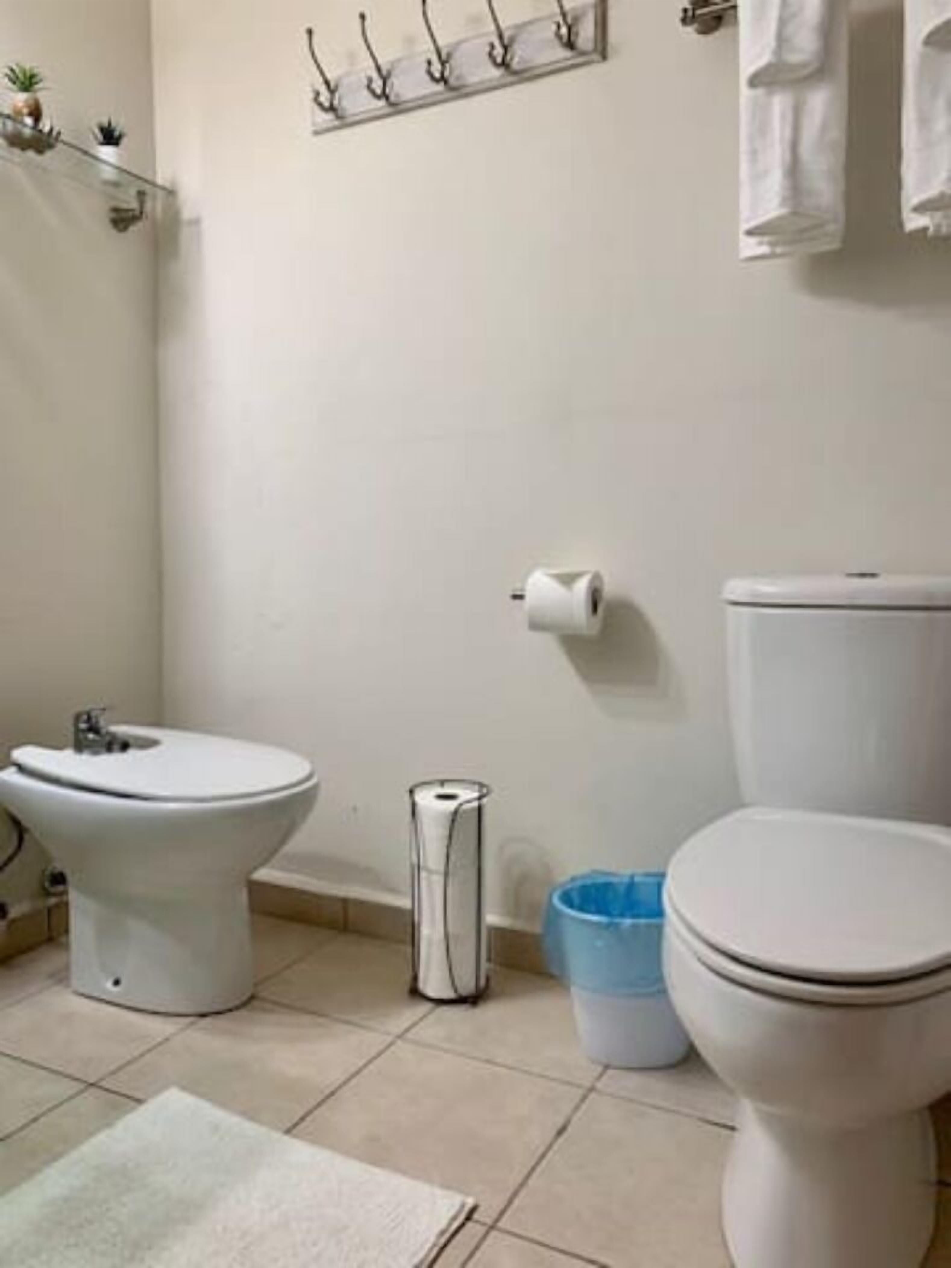 Ein Badezimmer mit Bidet, Toilette und Mülleimer.