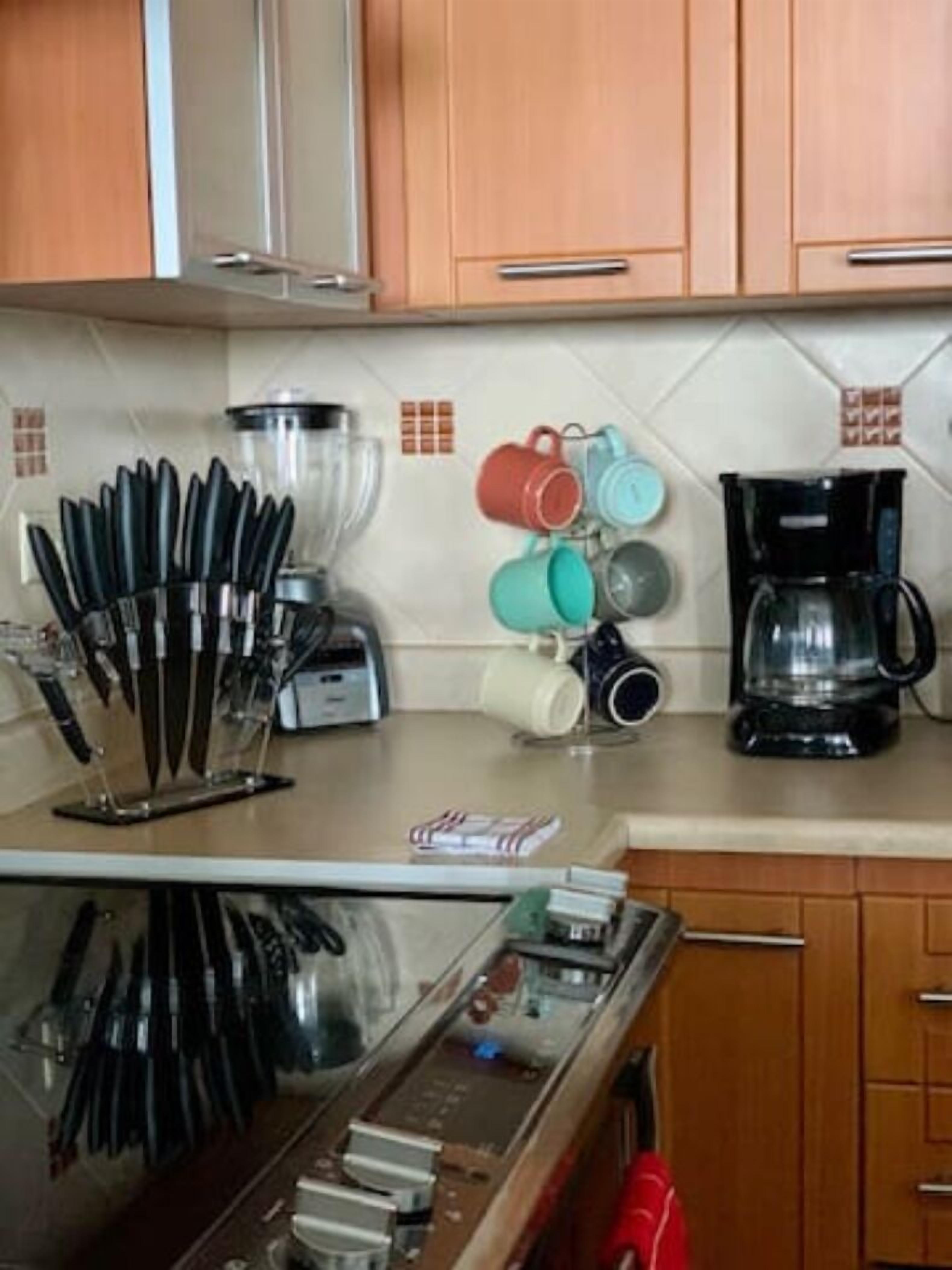 Eine Küche mit Holzausstattung, einer Kaffeemaschine, einem Toaster und einem Messerblock.