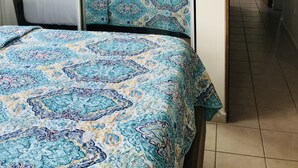 Ein Schlafzimmer mit einem Bett, einem Deckenventilator und einem Fenster.