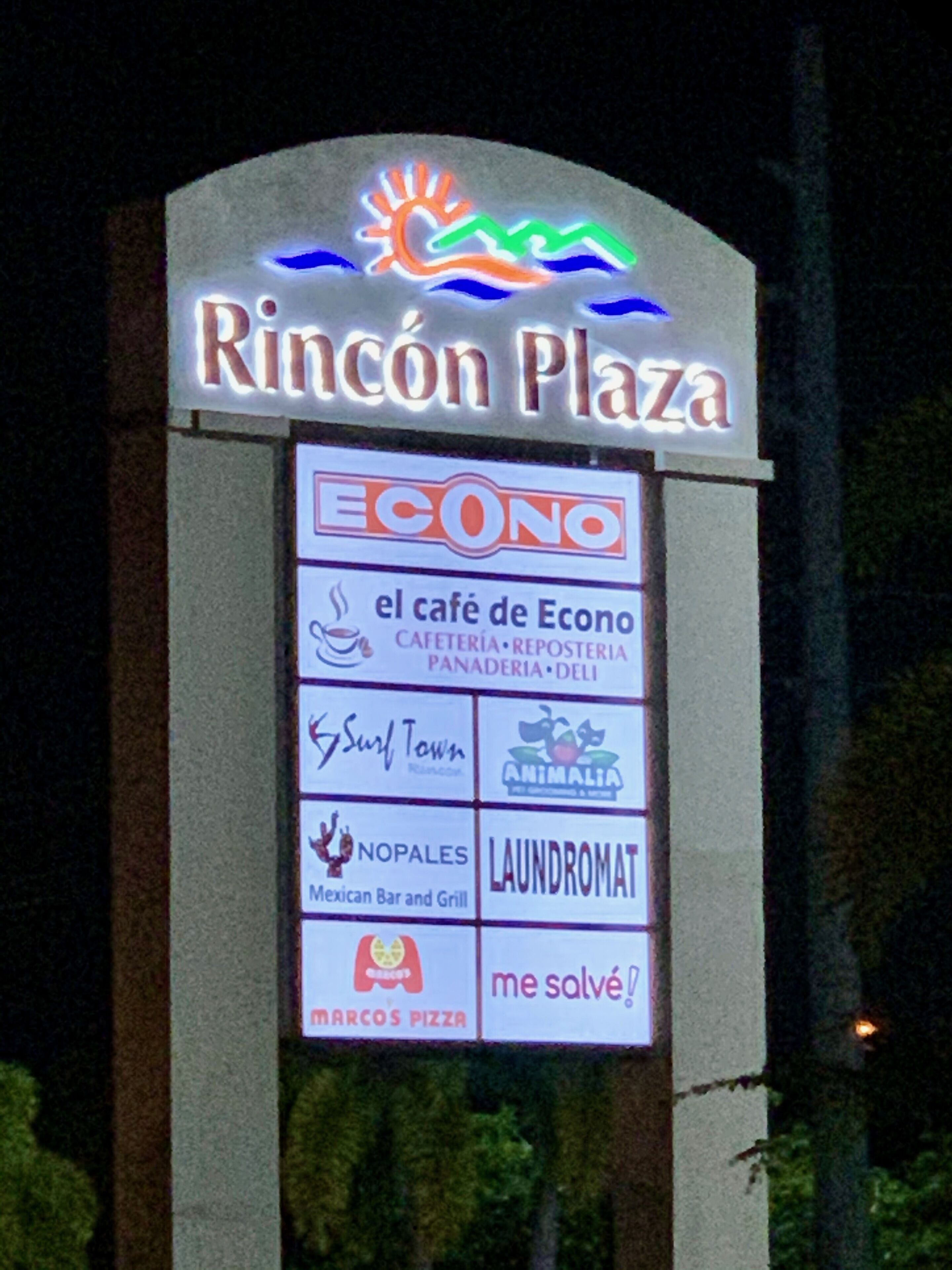 Un cartel para Rincón Plaza con varios nombres de negocios listados abajo.