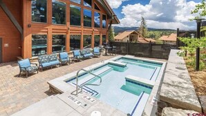 A pool area with lounge chairs and a building with large windows. - ELKPOINT Ski-In/Out .. 4BR/4.5BA .. Sleeps 14 ..  Arcade-Shuffle Board-Foosball (Durango)
