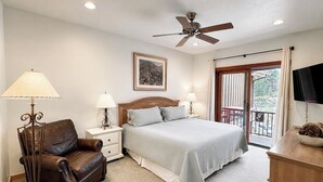 A bedroom with a bed, a chair, bedside tables, a ceiling fan, a picture on the wall, and a balcony with a view. - ELKPOINT Ski-In/Out .. 4BR/4.5BA .. Sleeps 14 ..  Arcade-Shuffle Board-Foosball (Durango)