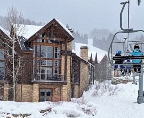 A snow-covered lodge with a ski lift in the background.
