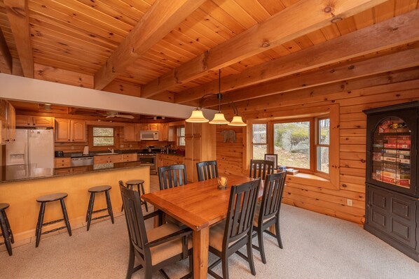 L’intérieur d’un chalet en bois comprend un coin repas, une cuisine et un bar.