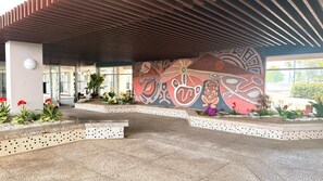 A modern building entrance with a tiled floor, a decorative mural, and potted plants. - CB118-St Balcony & Ocean View (Carolina)