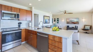A modern kitchen with stainless steel appliances, wooden cabinets, and a central island. - Panoramic Breathtaking Ocean-Sunset-Bali Hai Views A/C + Surf Crashing Below! (Princeville)
