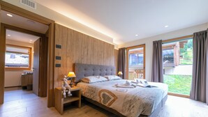 A bedroom with a large bed, wooden headboard, bedside lamps, and a view of the outdoors. - Casa Luminosa Ski in -Ski out 100m, Livigno, Italy (Livigno)