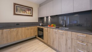 A modern kitchen with wooden cabinets, a stainless steel sink, and a built-in oven. - Casa Luminosa Ski in -Ski out 100m, Livigno, Italy (Livigno)