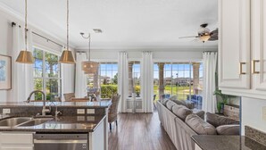 A spacious kitchen with a central island, a dining area with a view, and a cozy seating area. - 5 Bedroom Resort Villa w/Private Pool + Hot Tub | 1 Exit from Disney (Kissimmee)