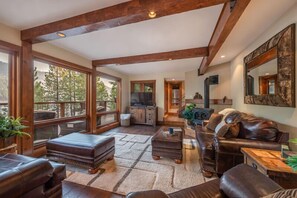 Relax in this cozy living space with a fireplace, comfortable sofa, and stunning views of the surrounding landscape.