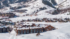 A snow-covered resort with multiple buildings, ski lifts, and a mountainous backdrop. - Walk to Skiing Exceptional Juniper Landing 4 BR+Den Private Hot Tub Panoramic Golf Course Views Pool (park city)