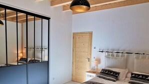 Un dormitorio con cama, mesitas de noche, un espejo y un armario.