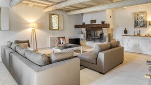 A living room with a fireplace, sofas, a coffee table, and a television. - A l'Isle sur la Sorgue, charme provençal (L'Isle-sur-la-Sorgue)
