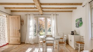 A dining area with a round table, white chairs, and a wooden ceiling. - A l'Isle sur la Sorgue, charme provençal (L'Isle-sur-la-Sorgue)