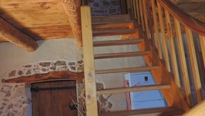 A wooden staircase with a stone wall and a wooden door at the bottom. - Charming 19th-Century Farmhouse near Loire Gorges, Cozy Interior, Baby Equipment, Optional Services (Aurec-sur-Loire)
