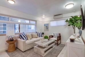 A modern living room with a sofa, coffee table, and a TV.