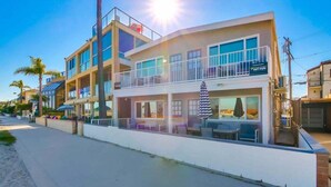 Ein mehrstöckiges Gebäude mit Balkonen, Außenplätzen und einem Schild im Surf-Stil.