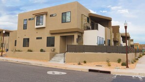 A modern two-story building with a flat roof, large windows, and a balcony.