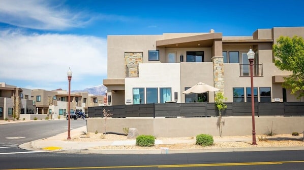 A modern multi-story building with a flat roof, large windows, and a stone facade.