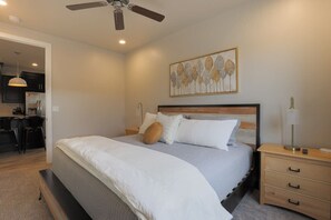 A bedroom with a bed, bedside tables, a ceiling fan, and a wall-mounted artwork. - Private Hot Tub | 5 Beds| Near Zion & Golf (Washington)