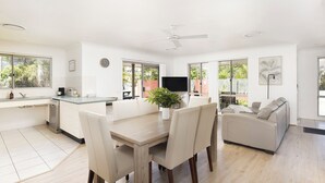 Una cocina moderna con comedor, televisor y sofá.