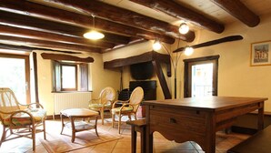 Una stanza rustica con arredi in legno, un camino e un pavimento piastrellato.