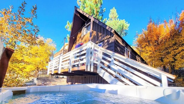 Une cabane en bois avec un jacuzzi et une terrasse.