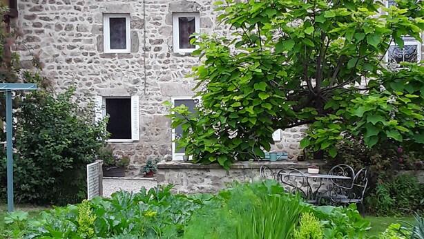Ein Steinhaus mit einem Garten davor.