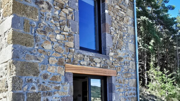 Un edificio de piedra con puerta de madera y una ventana.