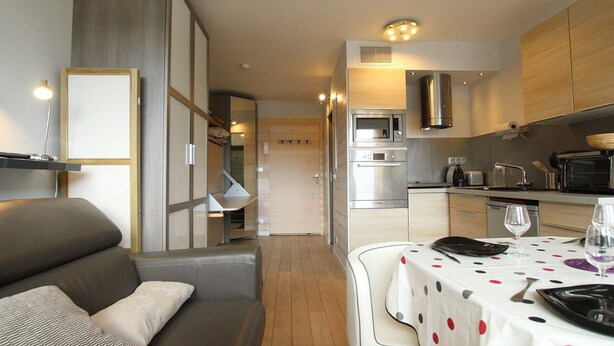 A compact living space with a kitchenette, a dining area, and a seating area.
