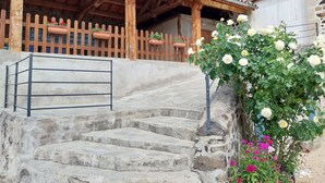 A stone staircase leading to a wooden porch with a tiled roof.