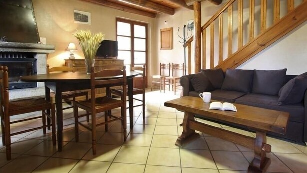 Un salon chaleureux avec une cheminée, des meubles en bois et un escalier.