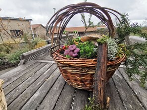 A wicker basket filled with plants and mushrooms on a wooden deck. - Family Cottage in Riotord with Garden and Playground (Riotord)