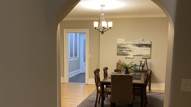 A dining area with a wooden floor, a chandelier, and a dining table with chairs. - Close to Downtown & UWEC (Eau Claire)