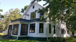 A two-story house with a wrap-around porch, large windows, and a steeply pitched roof. - Close to Downtown & UWEC (Eau Claire)