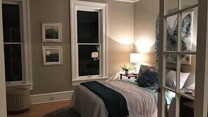 A bedroom with a bed, two windows, a nightstand, and a lamp. - Close to Downtown & UWEC (Eau Claire)