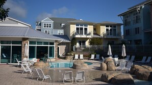 A pool area with lounge chairs and umbrellas, surrounded by buildings with balconies and large windows. - Modern 2 Bedrooms, 2.5 Baths in Beautiful IBIS section of Seapointe Village (Wildwood Crest)