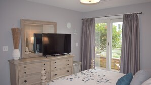 A bedroom with a bed, a dresser, a television, and a window with curtains. - Modern 2 Bedrooms, 2.5 Baths in Beautiful IBIS section of Seapointe Village (Wildwood Crest)