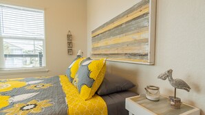 A bedroom with a bed, a nightstand, a wall clock, a painting, and a window with blinds. - Top floor upscale contemporary space with great views and great location (Galveston)