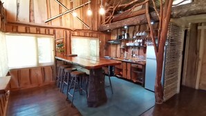A rustic kitchen with wooden walls and a large island. - Cabañas Rústicas Pucón (Pucon)