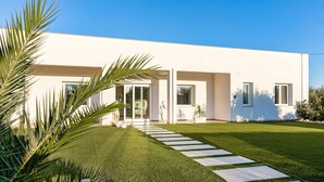 A modern house with a white exterior, a well-maintained lawn, and a stone pathway leading to the entrance. - Gorgeous home in Castelvetrano (Castelvetrano)