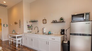 A kitchen with white cabinets, a stainless steel refrigerator, a microwave, and a coffee maker. - Top floor upscale contemporary space with great views and great location (Galveston)