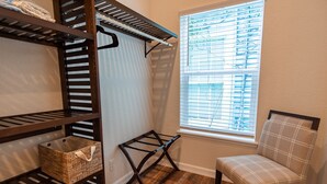 A room with a wooden floor, a window with blinds, a chair, and shelves with baskets. - Top floor upscale contemporary space with great views and great location (Galveston)