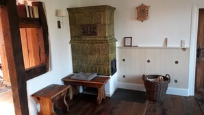 Ein gemütliches Zimmer mit einer Holzbank, einer grünen Wanddekoration, einem Korbwäscher und einer weißen Heizung.